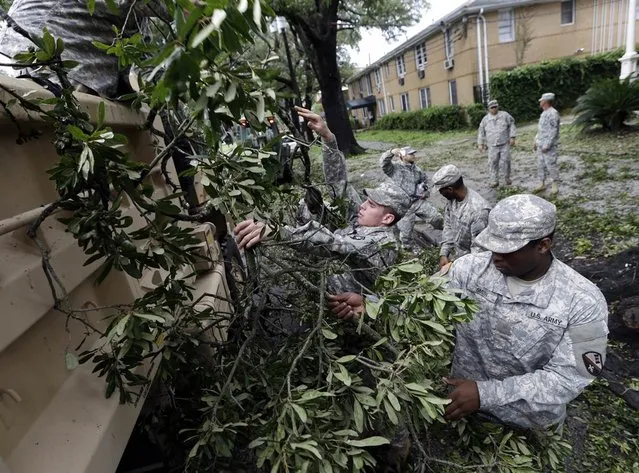 Members of the Louisiana National Guard clean up fallen branches along St. Charles Ave. in New Orleans on Aug. 30. (Photo by David J. Phillip/AP)