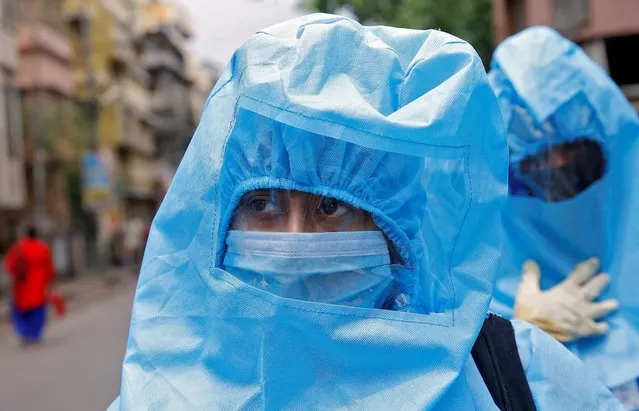 Health workers wearing protective gear are pictured during a door-to-door verification of people to find out if they have developed any coronavirus disease (COVID-19) symptoms, in a residential area in Kolkata, India, April 21, 2020. (Photo by Rupak De Chowdhuri/Reuters)
