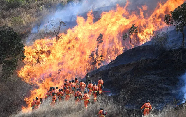 Fire fighters work to control a blaze in Sichuan province, Xichang, China on April 20, 2020. (Photo by Top Photo Corporation/Rex Features/Shutterstock)