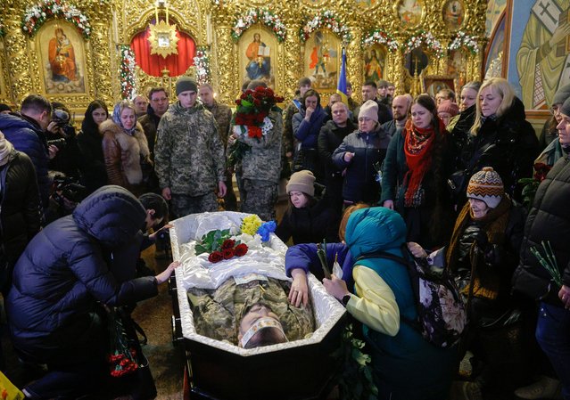 Relatives, friends, and comrades of late Ukrainian Marine officer Andriy Kuzmenko attend his farewell ceremony at St. Mykhailivskyi Cathedral in Kyiv, Ukraine, 10 January 2025. Andriy Kuzmenko joined the 35th Marine Brigade of the Ukrainian Ground Forces as a volunteer in 2023, fought in the Kherson region of Ukraine, and died on 04 January 2025. Russian troops entered Ukrainian territory on 24 February 2022, starting a conflict that has provoked destruction and a humanitarian crisis. (Photo by Sergey Dolzhenko/EPA/EFE)