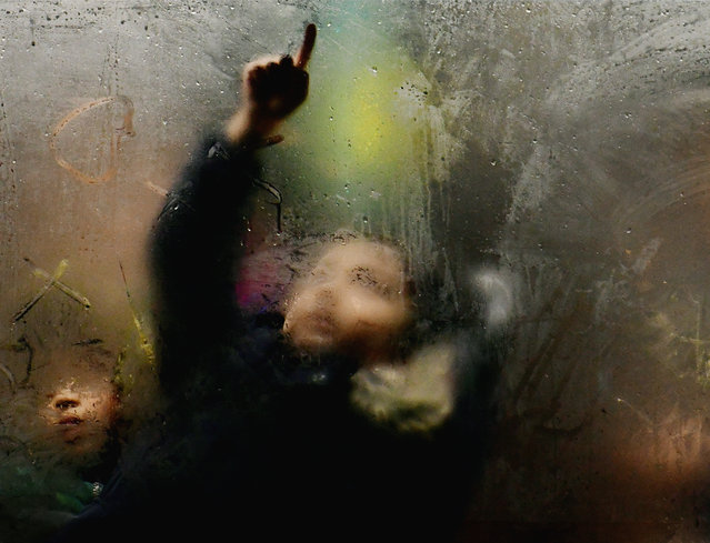 An image from Steve Madden’s forthcoming book The Grind. In October 2005, BBC presenter Steve Madden was standing in Shaftesbury Avenue when he saw a woman on the 38 bus, her figure framed by the misted-up window, which reflected the lights from the street. He took a snapshot and, years later, struck by a similar scene, he had the idea for a photography series. (Photo by Steve Madden)