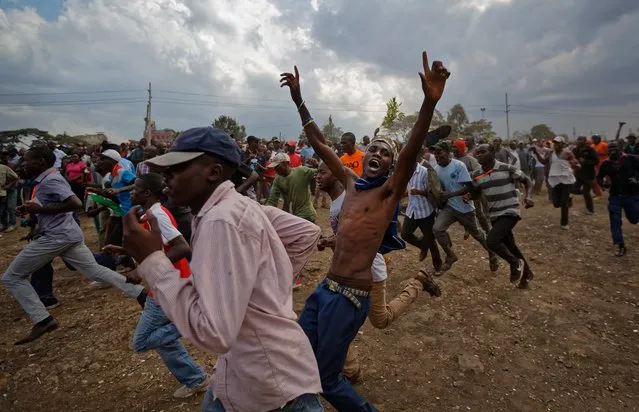 Supporters of Kenyan opposition leader Raila Odinga run through the crowd prior to his arrival at a mass rally in the Shauri Moyo area of Nairobi, Kenya Wednesday, October 18, 2017. The head of the election commission said Wednesday that it is “difficult to guarantee a free, fair and credible election” in Kenya's fresh presidential vote only eight days away, just hours after a top Kenyan electoral official resigned saying the election on Oct. 26 cannot be credible as planned. (Photo by Ben Curtis/AP Photo)