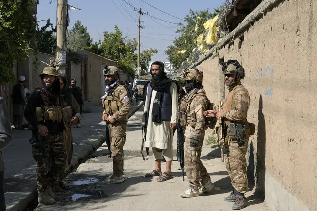 Taliban fighters stand guard in front of an education center that was attacked by a suicide bomber, in Kabul, Afghanistan, Friday, September 30, 2022. (Photo by Ebrahim Noroozi/AP Photo)