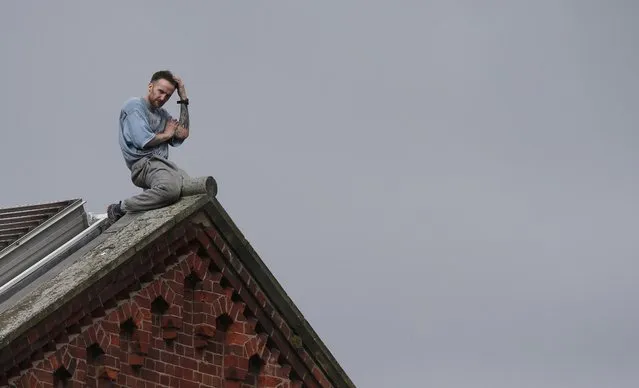 Prisoner Stuart Horner sits on the roof of Manchester's 'Strangeways' prison in Manchester, Britain, September 15, 2015. Horner, a convicted murderer, has so far spent 2 nights on the prison roof protesting about conditions inside the jail. (Photo by Phil Noble/Reuters)