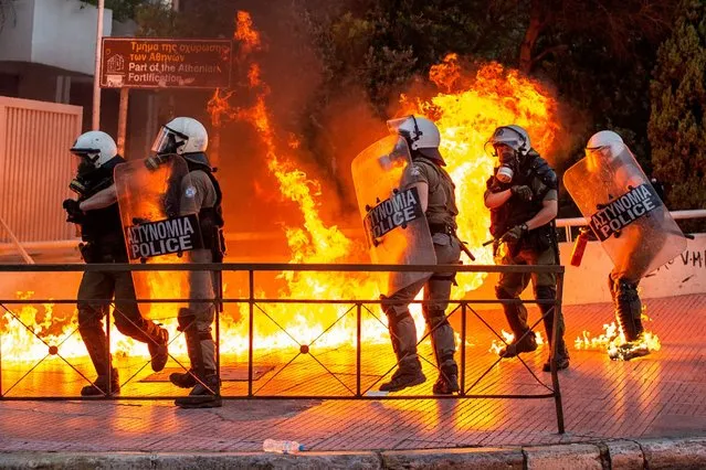 Riot police officers try to avoid patrol bombs thrown by protesters outside the Greek Parliament during a demonstration against a new law on protest rules in Athens, on July 9, 2020. Thousands of Greeks demonstrated on July 9 against a new law tightening street protest rules that has been criticised by the opposition as undemocratic. Outside parliament in Athens, some protesters threw firebombs at police as the government majority was expected to approve the bill in an evening vote. Around 10,000 people participated in three separate Athens protests against the new law, a police source said. (Photo by Angelos Tzortzinis/AFP Photo)