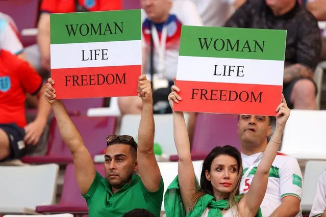 Iranian fans hold up signs prior to the FIFA World Cup Qatar 2022 Group B match between England and IR Iran at Khalifa International Stadium on November 21, 2022 in Doha, Qatar. (Photo by Julian Finney/Getty Images)