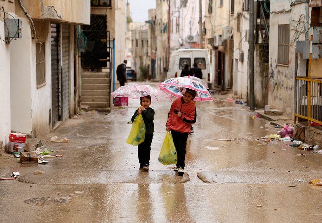Palestinians children carry bottles of water amid disruption of water supply, in the aftermath of an Israeli raid, in Al-Faraa refugee camp near Tubas, in the Israeli-occupied West Bank on February 12, 2025. (Photo by Raneen Sawafta/Reuters)