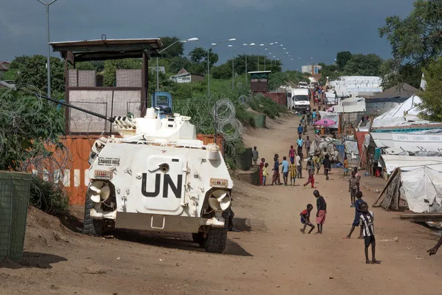 In this Monday, July 25, 2016 file photo, some of the more than 30,000 civilians sheltering in a United Nations base in South Sudan's capital Juba  walk by an armored vehicle and a watchtower manned by Chinese UN peacekeepers. The U.N. Security Council is expected to arrive in South Sudan on Friday, September 2, 2016 for a three-day visit to the troubled nation on the edge of renewed civil war. (Photo by Jason Patinkin/AP Photo)