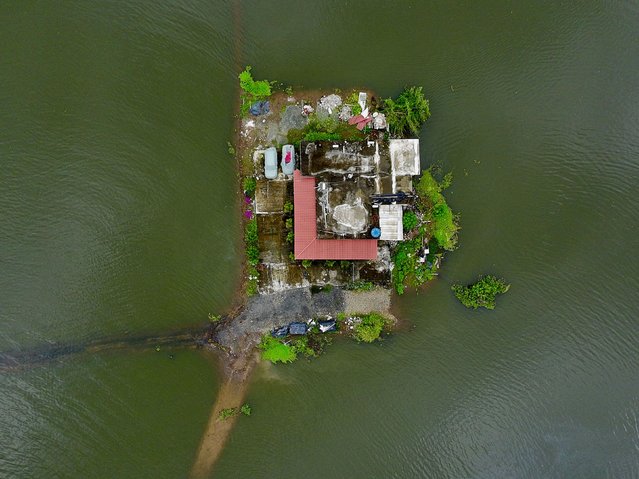 This aerial photo shows a house flooded because of heavy rain in Jujan, Ecuador, on Wednesday, March 12, 2025. (Photo by Marcos Pin/AFP Photo)