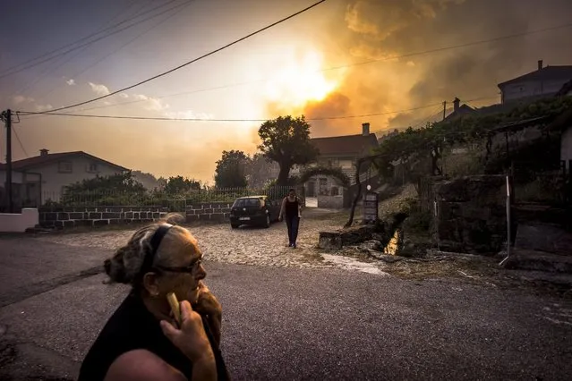 Residents look on as the forest fire rages in the area of Vila do Soajo, northern Portugal, 06 September 2016. (Photo by Goncalo Delgado/EPA)