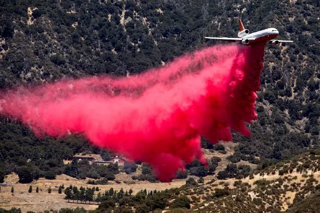 An air tanker drops fire retardant at the Apple Fire in Cherry Valley, Calif., Saturday, August 1, 2020. A wildfire northwest of Palm Springs flared up Saturday afternoon, prompting authorities to issue new evacuation orders as firefighters fought the blaze in triple-degree heat. (Photo by Ringo H.W. Chiu/AP Photo)
