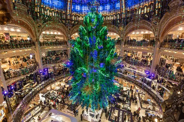 The traditionnal giant Christmas tree of the Galeries Lafayette department store stands under its great dome in Paris, France, 21 December 2022. (Photo by Christophe Petit Tesson/EPA/EFE)