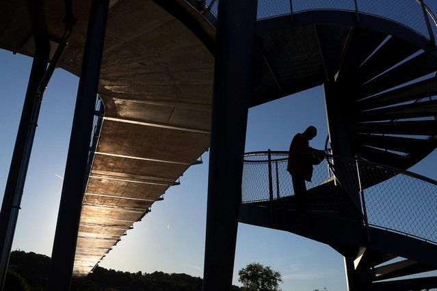 The light of the low sun is reflected on the underside of a pedestrian bridge from the surface of the River Main in Bavaria on May 10, 2025. (Photo by Karl-Josef Hildenbrand/dpa)