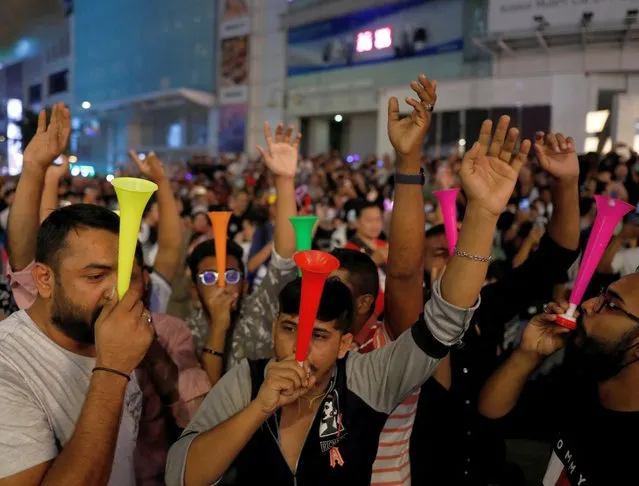 Revelers blow horn as they celebrates New Year's Eve in Kuala Lumpur, Malaysia on December 31, 2022. (Photo by Hasnoor Hussain/Reuters)