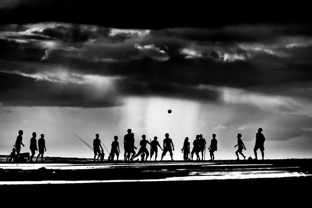 Winner. “Pekutatan beach, Bali. About an hour before sunset kids would gather to play football – and stay until dark. I photographed them over several days, hoping to get a nice sunset silhouette. That never came but there were glimpses of it and lots of storm clouds”. MICK RYAN, JUDGE: “If a photo is sometimes meant to tell a story, this has several chapters. A well-spotted scene by a photographer who was some distance away and taken with a telephoto lens that has compressed the action. I like the conversion to monotone, which with silhouettes can add more impact by its simplification”. (Photo by Ian Webb/The Guardian)