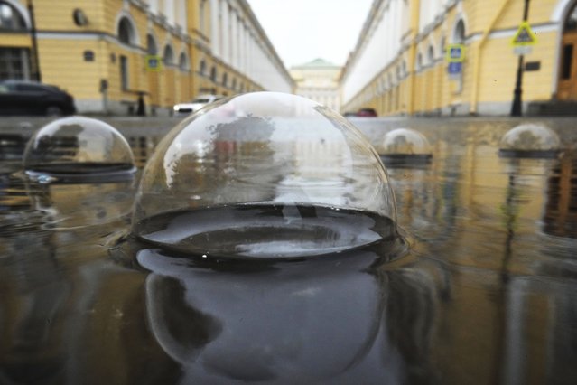 Bubbles form on a puddle during rainfall in central St. Petersburg, Russia, Sunday, June 29, 2025. (Photo by Dmitri Lovetsky/AP Photo)