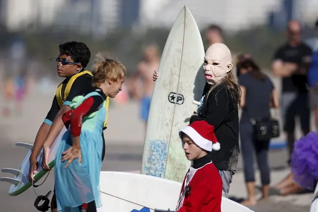 Joey Callhehan, 13, (R) prepares to surf dressed as a baby during the ZJ Boarding House Haunted Heats Halloween Surf Contest in Santa Monica, California, United States, October 31, 2015. (Photo by Lucy Nicholson/Reuters)