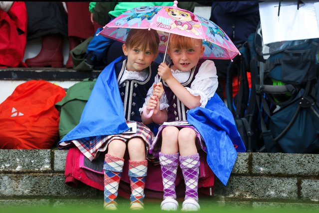 Two dancers keep warm during the Argyllshire Gathering on August 28, 2025 in Oban, Scotland. The Oban Games, a day of intense Highland rivalries and competition, are a key part of the historic Argyllshire Gathering. Founded in 1871, the Gathering began as a way to unite the clans of Argyll — a region encompassing over 20 islands on the western coast of Scotland — through traditional Highland sports. Over time, it has evolved into an annual summer celebration of Scottish heritage and community. (Photo by Jeff J. Mitchell/Getty Images)