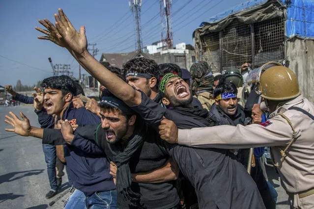Kashmiri Shiite Muslims shout religious and pro-freedom slogan as Indian policemen stop them from for participating in a religious procession during curfew in Srinagar, Indian controlled Kashmir, Monday, October 10, 2016. Authorities in Indian portion of Kashmiri imposed restrictions in some parts of Srinagar fearing religious processions marking the Muslim month of Muharram would turn into anti-India protests. (Photo by Dar Yasin/AP Photo)