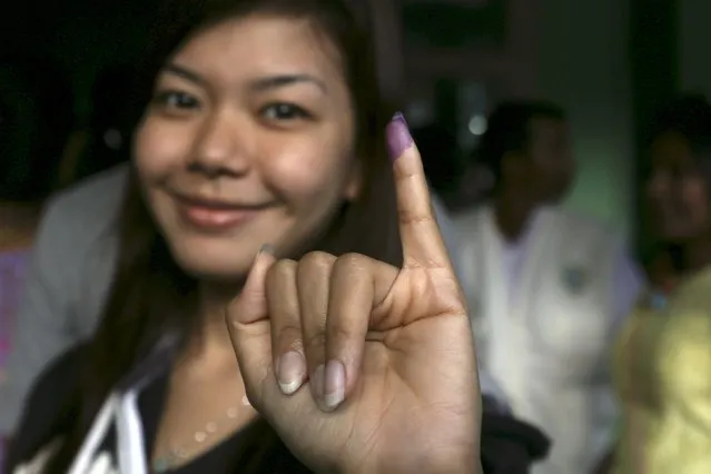 A woman shows her inked finger after casting her ballot during general elections in Yangon November 8, 2015. (Photo by Soe Zeya Tun/Reuters)