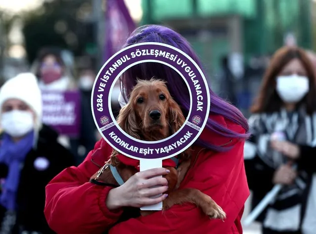 A woman protestor holds her dog and a placard reading “Women will live equally”, during a rally for the “prevention of violence against women” in Istanbul, Turkey, 22 November 2020. According to the “We'll Stop Femicide” social platform, 335 women were killed through gender violence and hundreds assaulted by men in 2020, in Turkey. (Photo by Sedat Suna/EPA/EFE)