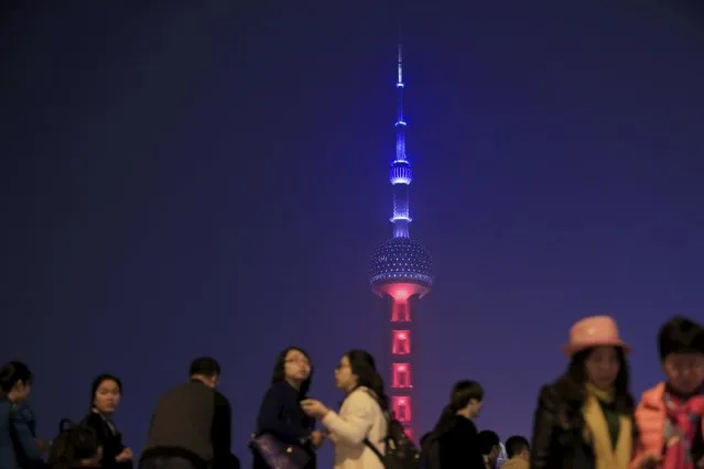 Shanghai's landmark building Oriental Pearl TV Tower is lit up in blue, white and red, the colors of the French flag, following the Paris attacks, in Shanghai, China, November 14, 2015. (Photo by Aly Song/Reuters)