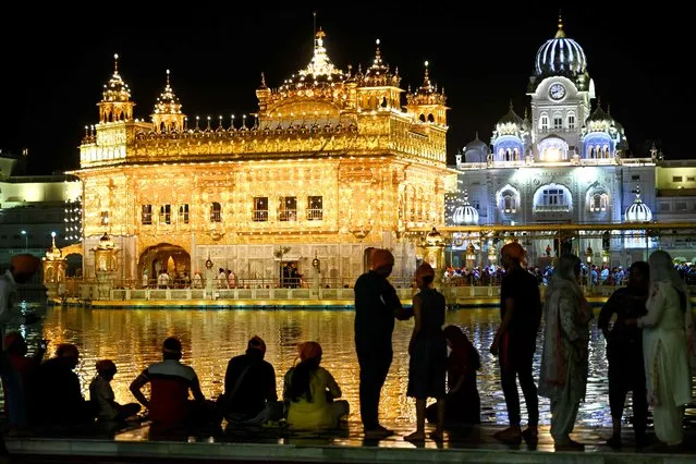 Devotees visit the illuminated Golden Temple on the eve of birth anniversary of the ninth Sikh Guru Teg Bahadur, in Amritsar on April 10, 2023. (Photo by Narinder Nanu/AFP Photo)