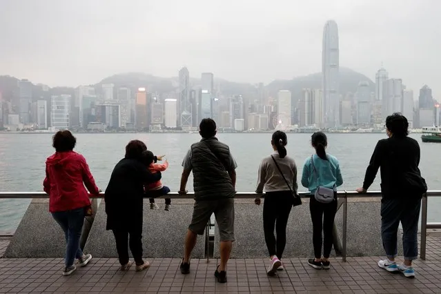 The Lai family, who are emigrating to Scotland, look out over the city's skyline on a outing to Tsim Sha Tsui in Hong Kong, China, December 14, 2020. (Photo by Tyrone Siu/Reuters)