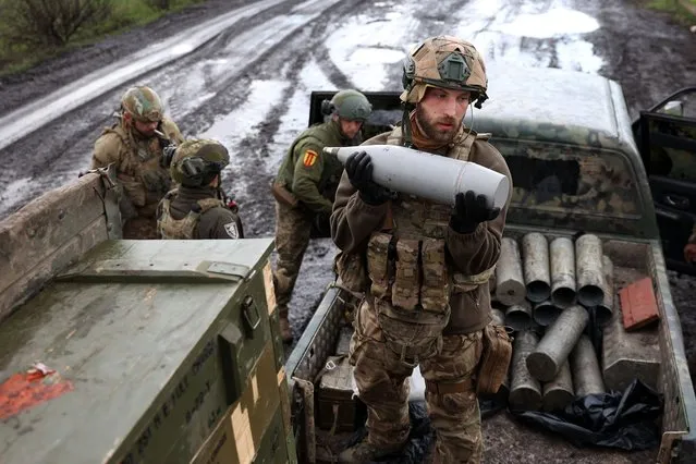 A Ukrainian artilleryman of the Aidar battalion holds an artillery shell on a front line position near Bakhmut, Donetsk region, on April 22, 2023, amid the Russian invasion on Ukraine. (Photo by Anatolii Stepanov/AFP Photo)