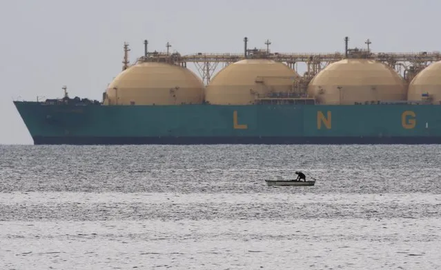 A fisherman stands in his boat as a liquid natural gas tanker (LNG) passes the coast near Havana in this June 28, 2009 file photo. The Philippines is set to import liquefied natural gas (LNG) for the first time in 2016 as it bids to replace fast-fading local gas supplies, but cheap coal is blowing off course Manila's vow to lift the use of cleaner fuels. (Photo by Desmond Boylan/Reuters)