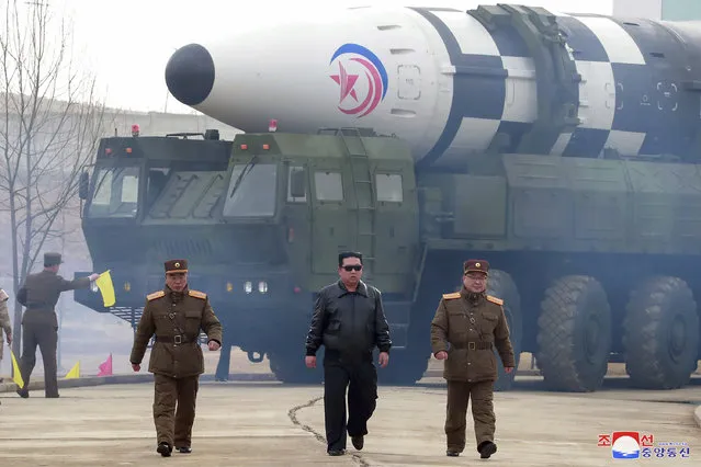 In this photo distributed by the North Korean government, North Korean leader Kim Jong Un, center, walks around what it says a Hwasong-17 intercontinental ballistic missile (ICBM) on the launcher, at an undisclosed location in North Korea on March 24, 2022. Independent journalists were not given access to cover the event depicted in this image distributed by the North Korean government. The content of this image is as provided and cannot be independently verified. Korean language watermark on image as provided by source reads: “KCNA” which is the abbreviation for Korean Central News Agency. (Photo by Korean Central News Agency/Korea News Service via AP Photo)