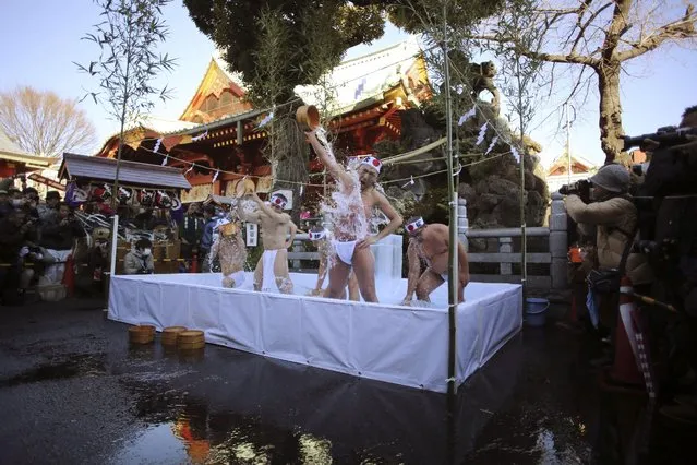 Half-naked shrine parishioners using a wooden tub pours cold water onto themselves during an annual cold-endurance festival at the Kanda Myojin Shinto shrine in Tokyo, Saturday, January 10, 2015. (Photo by Eugene Hoshiko/AP Photo)