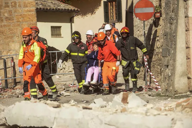 Firefighters and rescuers carry a woman on a wheelchair after a 6.6 magnitude earthquake on October 30, 2016 in Norcia. It came four days after quakes of 5.5 and 6.1 magnitude hit the same area and nine weeks after nearly 300 people died in an August 24 quake that devastated the tourist town of Amatrice at the peak of the holiday season. Italy's most powerful earthquake in 36 years dealt a new blow Sunday to the country's seismically vulnerable heart, sending terrified residents fleeing for the third time in nine weeks and flattening a revered six-century-old church. (Photo by Fabrizio Troccoli/AFP Photo)