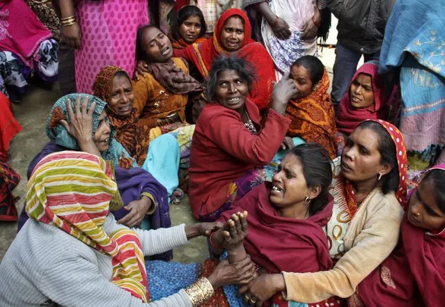 Family members mourn for their relatives, who died after consuming bootleg liquor, outside their residence at Malihabad town in the northern Indian state of Uttar Pradesh January 13, 2015. (Photo by Pawan Kumar/Reuters)