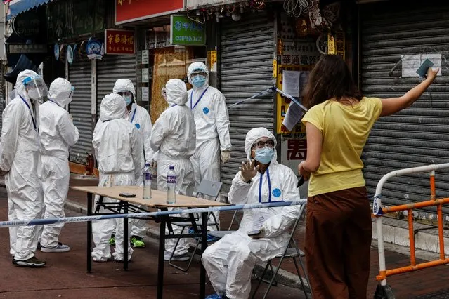 A resident talks to health workers inside a locked down portion of the Jordan residential area to contain a new outbreak of the coronavirus disease (COVID-19), in Hong Kong, China on January 23, 2021. (Photo by Tyrone Siu/Reuters)