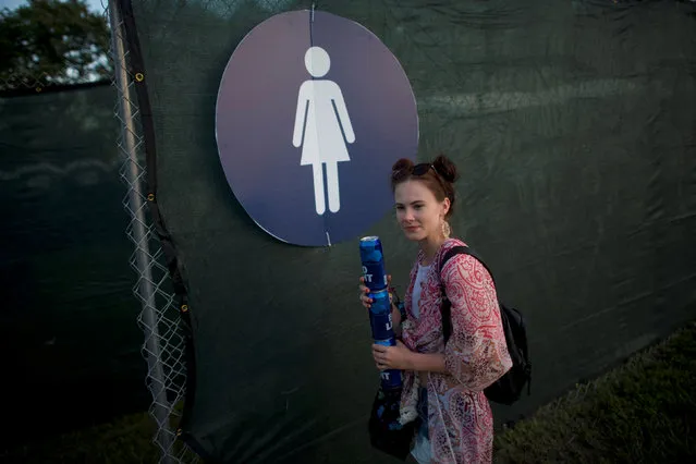Amber Wilson, 20, holds beer cans while her friends use the portable restroom during the Firefly Music Festival in Dover, Delaware June 14, 2018. (Photo by Mark Makela/Reuters)