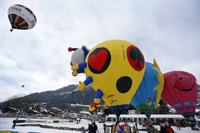 Balloons of all shapes and sizes get ready for take off at the 37th International Hot Air Balloon Week in Chateau-d'Oex, January 24, 2015. (Photo by Pierre Albouy/Reuters)