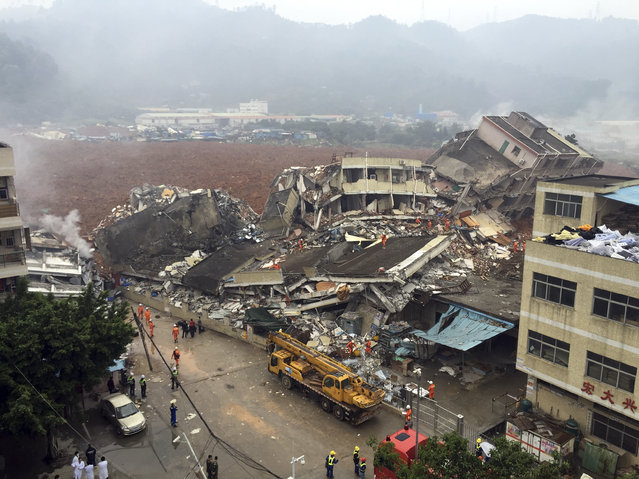 Rescuers search for survivors amongst collapsed buildings after a landslide in Shenzhen, in south China's Guangdong province, Sunday, December 20, 2015. (Photo by Chinatopix via AP Photo)