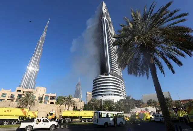Plumes of smoke rise from the 63-storey Address Downtown Dubai hotel and residential block near the Burj Khalifa, the tallest building in the world, a day after the hotel caught fire on New Year's Eve, in Dubai January 1, 2016. (Photo by Reuters/Stringer)