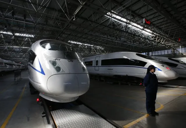 An employee stands next to high speed railway model CRH380B trains at a production line of its parts at China CNR's Tangshan Railway Vehicle's factory in Tangshan, Hebei province, February 11, 2015. (Photo by Kim Kyung-Hoon/Reuters)