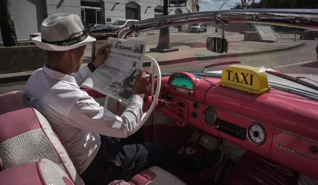 A taxi driver reads the newspaper in a street of Havana, on November 26, 2016, the day after Cuban revolutionary leader Fidel Castro died aged 90 One of the world' s longest- serving rulers and modern history' s most singular characters, Castro defied 11 US administrations and hundreds of assassination attempts. (Photo by Adalberto Roque/AFP Photo)