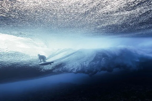 This underwater picture shows a surfer riding a wave at Teahupo'o in Tahiti, French Polynesia on August 11, 2023, during the WSL Shiseido Tahiti pro surfing event. Teahupo'o will host the surfing event of the Paris 2014 Olympic Games. (Photo by Ben Thouard/AFP Photo)
