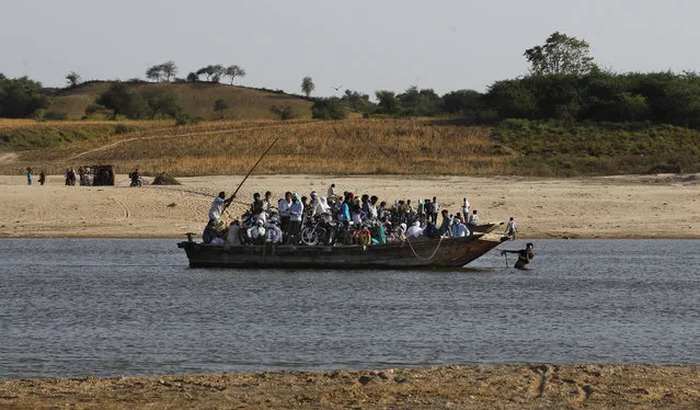 In this photo taken Monday, April 28, 2014, Indian villagers cross the River Chambal on a ferry near Bhopepura village in the northern Indian state of Uttar Pradesh. (Photo by Altaf Qadri/AP Photo)