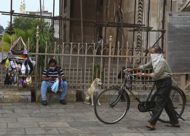 An Indian man awaits customers as he sells face masks on a street during the COVID-19 pandemic in Hyderabad, India, Monday, May 3, 2021. (Photo by Mahesh Kumar A./AP Photo)