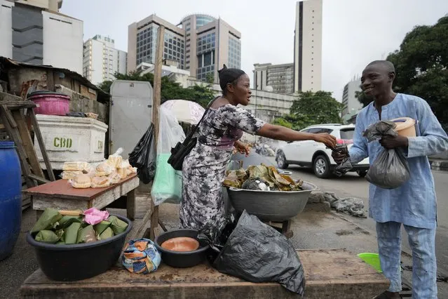 A woman sells boiled bean pudding made from a mixture of washed and peeled black-eyed beans, on the streets of Lagos, Nigeria, Tuesday September 5, 2023. (Photo by Sunday Alamba/AP Photo)