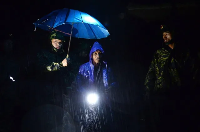 This photo taken on October 6, 2013 shows rescuers helping evacuate residents in typhoon-hit area in Cangnan, east China's Zhejiang province. Typhoon Fitow barrelled into China's east coast early on October 7, packing winds of more than 200 kilometres an hour after hundreds of thousands of people were evacuated, state media reported. (Photo by AFP Photo)