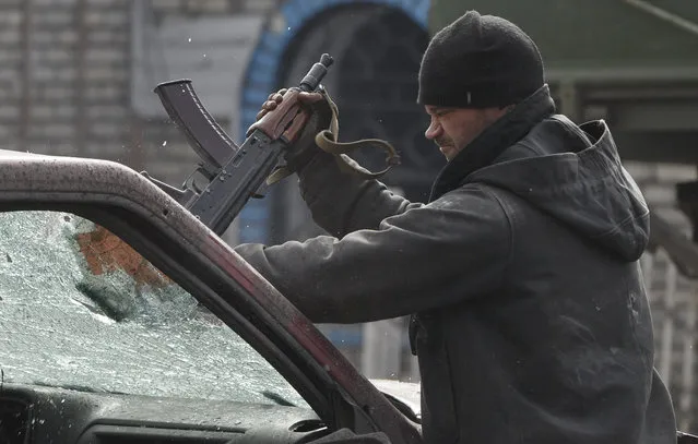 A Russia-backed rebel breaks the windshield of a vehicle with his weapon in Debaltseve, Ukraine, Friday, Feb. 20, 2015. After weeks of relentless fighting, the embattled Ukrainian rail hub of Debaltseve fell Wednesday to Russia-backed separatists, who hoisted a flag in triumph over the town. The Ukrainian president confirmed that he had ordered troops to pull out and the rebels reported taking hundreds of soldiers captive.(AP Photo/Vadim Ghirda)