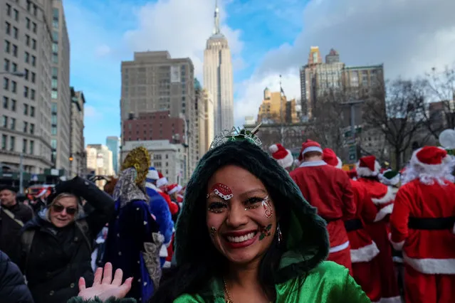 The Empire State Building is seen in the background as a reveller sports seasonal decorations while taking part in the annual SantaCon event in Manhattan, New York, December 10, 2016. (Photo by Jeenah Moon/Reuters)
