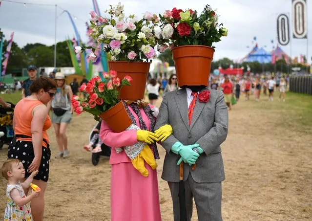 A young girl reacts as a couple dressed as flower pots walk around the site during day two of Glastonbury Festival at Worthy Farm, Pilton on June 23, 2022 in Glastonbury, England. (Photo by Dave J. Hogan/Getty Images)