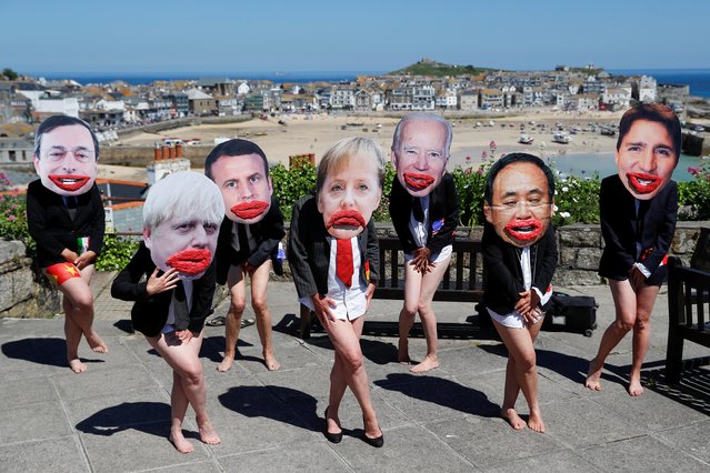 Extinction Rebellion activists wearing masks depicting G7 leaders pose during a protest under a slogan “All mouth and no trousers” to highlight male-dominated G7 leadership, during the G7 summit, in St Ives, Cornwall, Britain, June 13, 2021. (Photo by Peter Nicholls/Reuters)
